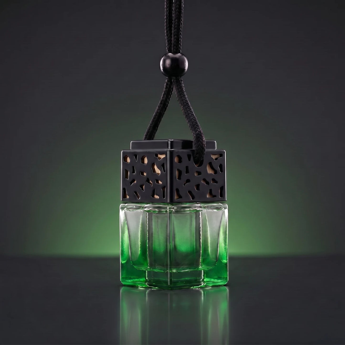 Green FRESURE car diffuser — green tinted glass cube bottle with black lattice cap on a dark studio background