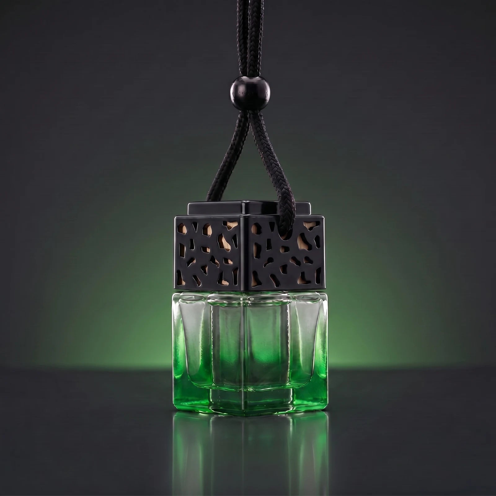 Green FRESURE car diffuser — green tinted glass cube bottle with black lattice cap on a dark studio background